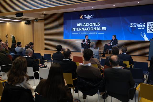 Un evento sobre relaciones internacionales con varios asistentes en un salón moderno.