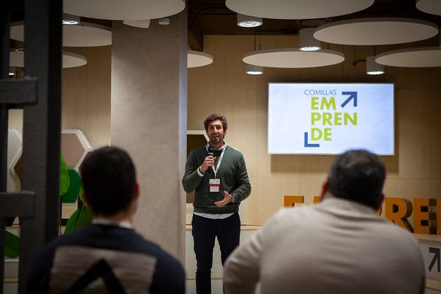 Un orador presenta en un evento de emprendimiento en un ambiente moderno.