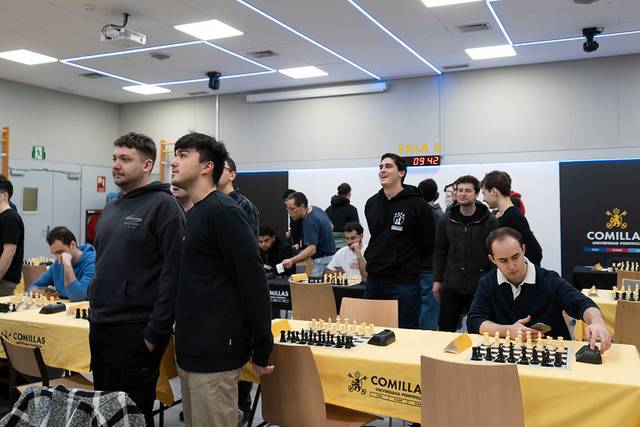 Un grupo de jóvenes participa en un torneo de ajedrez en un ambiente académico.