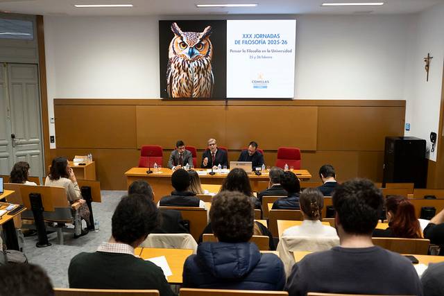 Un grupo de personas asiste a una conferencia sobre filosofía en un aula.