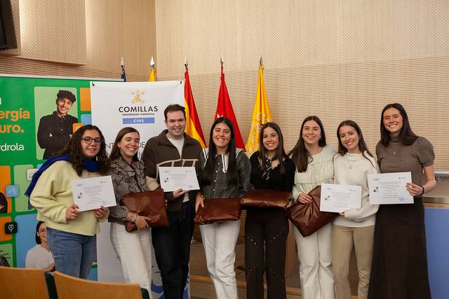 Un grupo de ocho personas sonrientes sostiene certificados en un evento en la universidad.