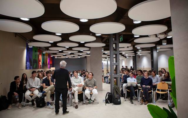 Una sala llena de estudiantes escuchando a un orador en un evento educativo.