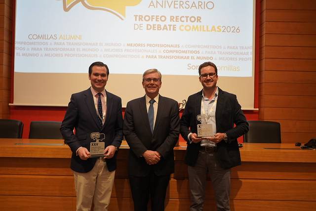 Una imagen de un evento de premiación en la que dos personas sostienen galardones junto a un hombre que parece ser un dignatario.