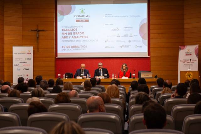 Una conferencia con varios ponentes en un auditorio lleno de asistentes.