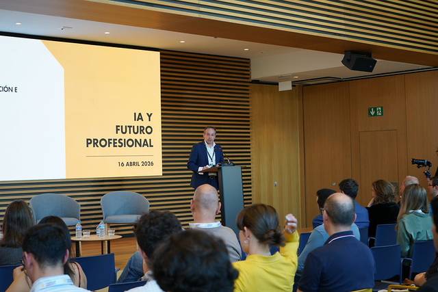Un conferencista presenta un evento sobre inteligencia artificial y futuro profesional ante una audiencia en un aula moderna.