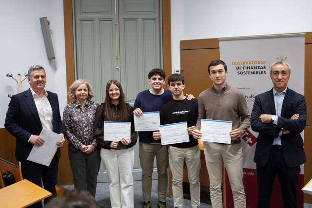 Un grupo de cinco personas sostiene certificados en un evento académico.