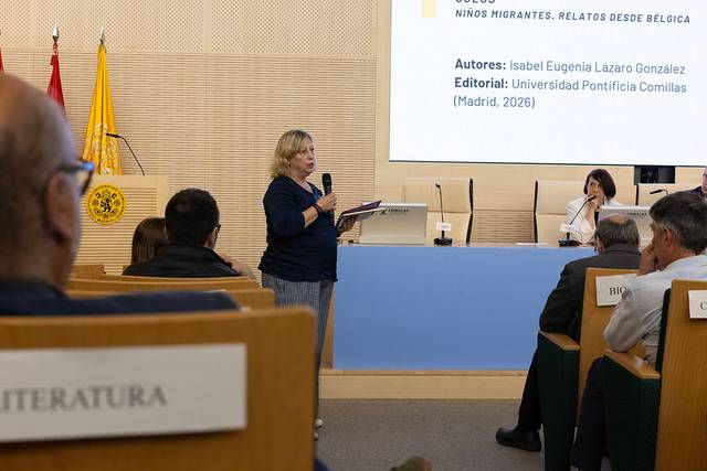 Una mujer habla en una conferencia mientras el público la escucha atentamente.