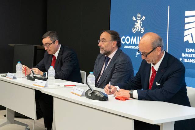 Tres personas sentadas en una mesa durante un evento formal.