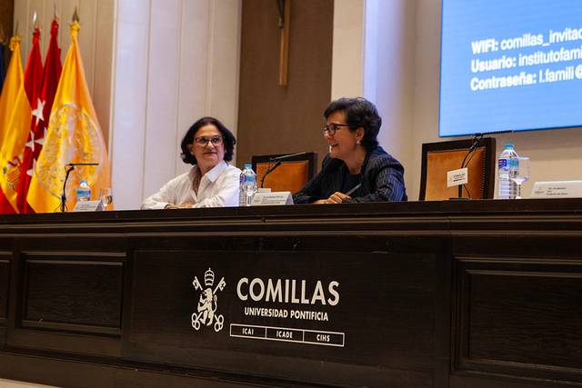 Una conferencia en la Universidad Pontificia Comillas con dos ponentes en la mesa.