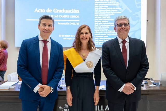 Imagen de un acto de graduación con tres personas posando en un escenario.