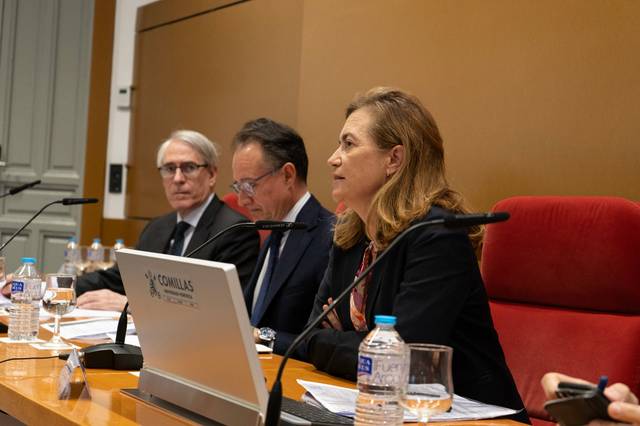 Tres personas sentadas en un panel de discusión en un entorno formal.
