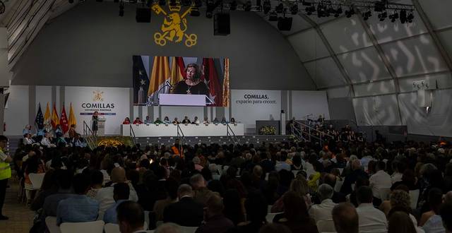 Un evento académico con una gran audiencia en un auditorio, donde una persona habla desde un podio.