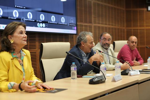 Un grupo de personas discutiendo en una mesa durante un evento.
