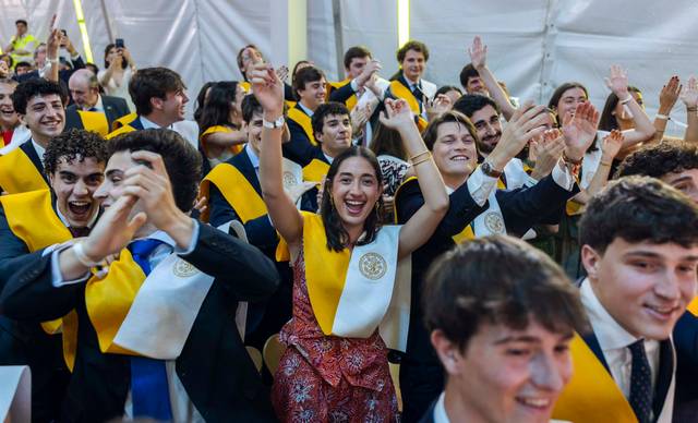 Un grupo de estudiantes celebra con entusiasmo durante una ceremonia de graduación.