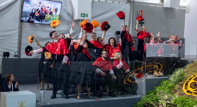 Un grupo de personas celebrando con birretes y sombreros de colores en un evento festivo.