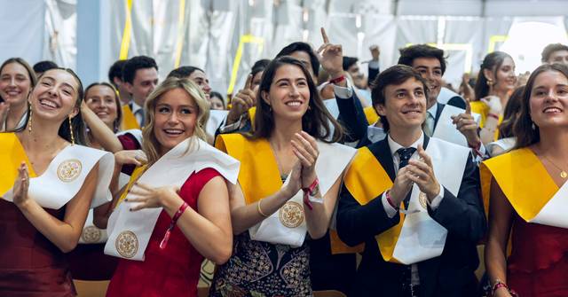 Un grupo de estudiantes celebrando su graduación con sonrisas y aplausos.