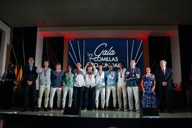 Un grupo de personas en un evento de premiación posando en un escenario.