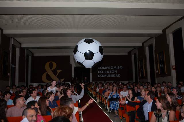 Un gran balón de fútbol flota sobre una multitud en un evento.