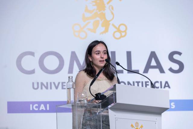 Una joven da un discurso en un evento en la Universidad Pontificia Comillas.