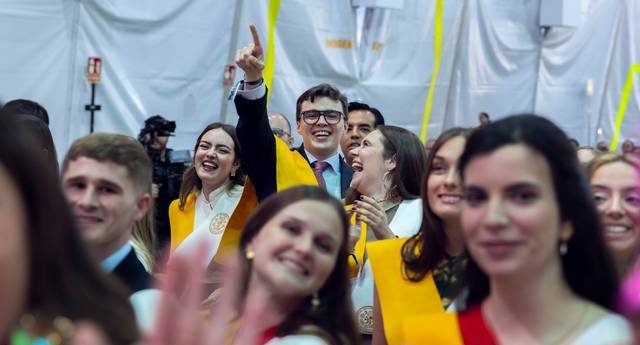 Un grupo de estudiantes celebrando en una ceremonia con sonrisas y ropa especial de graduación.