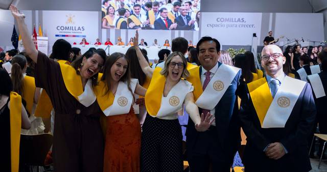 Un grupo de graduados sonrientes celebra su graduación en un evento formal en Comillas.