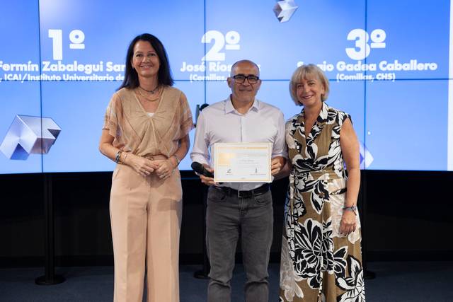 En la imagen, tres personas posan durante una ceremonia de entrega de premios, sosteniendo un certificado.