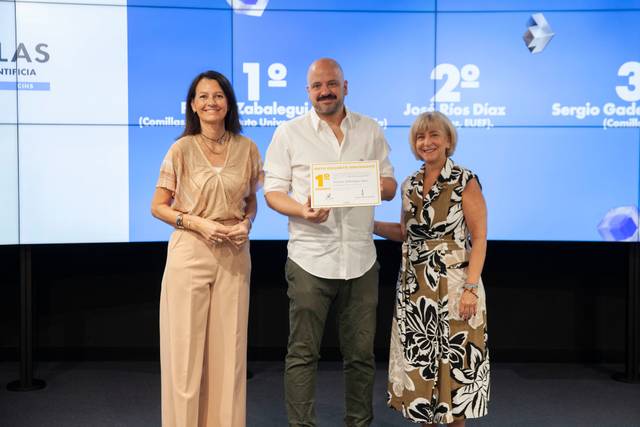 Tres personas posan juntas en un evento de premiación mostrando un certificado.