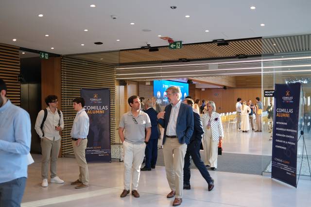 Un grupo de personas conversando en un moderno vestíbulo durante un evento de alumni.