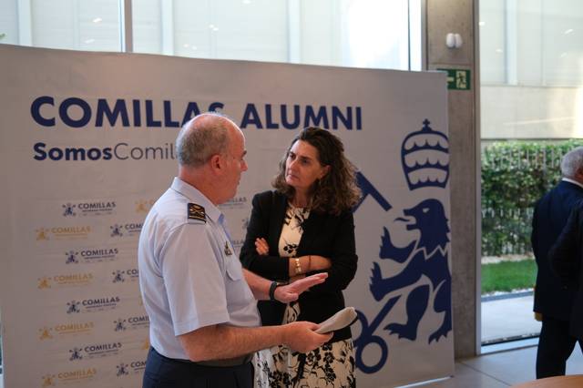 Dos personas conversan en un evento de Comillas Alumni.