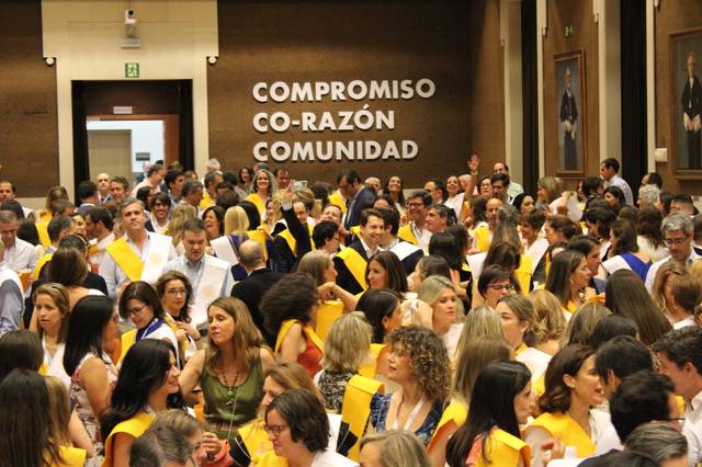 Un evento de graduación con muchas personas celebrando y usando bandas amarillas.