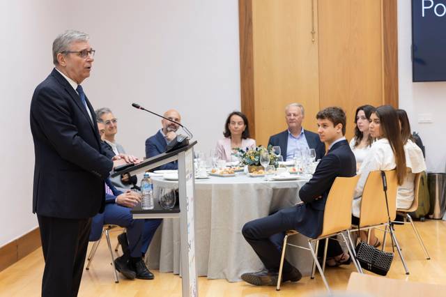 Un grupo de personas escucha atentamente a un orador en un evento formal.