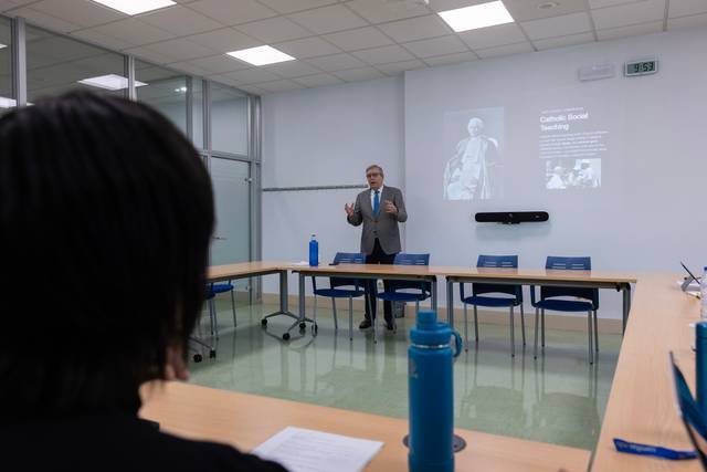 Un hombre da una presentación frente a una audiencia en una sala de conferencias.