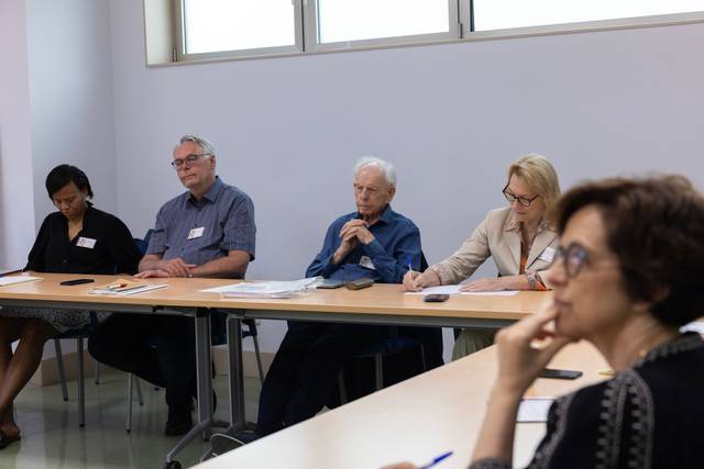 Un grupo de personas sentadas en una sala durante una reunión.