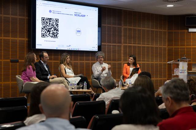 Una mesa redonda con varios ponentes discutiendo en un evento sobre tecnología y datos.