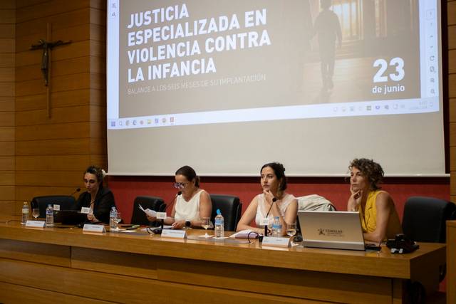 Un grupo de mujeres en una mesa discutiendo sobre justicia especializada en violencia contra la infancia en un evento.