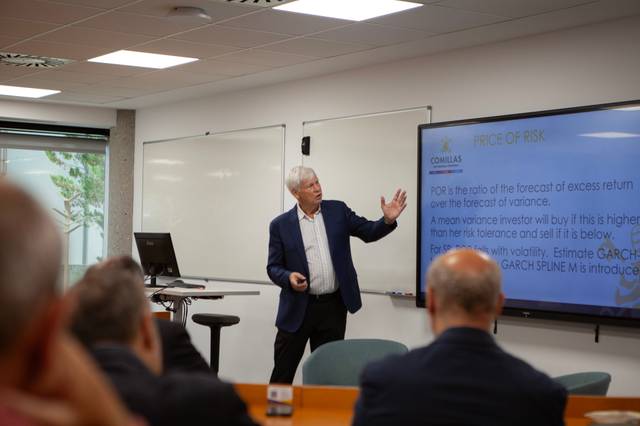 Un hombre mayor está dando una presentación en una sala de conferencias sobre el riesgo financiero.