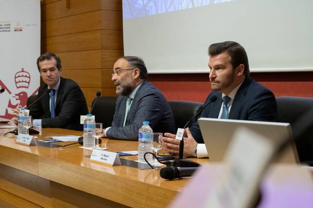 Una conferencia en la que tres ponentes participan en una mesa redonda.