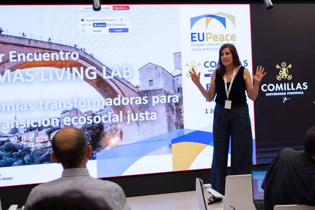 Una mujer está presentando en un evento sobre laboratorios vivientes en un entorno académico.