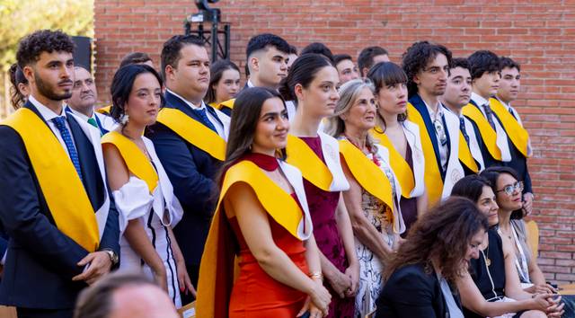 Un grupo de graduados en una ceremonia, luciendo togas y medallas.
