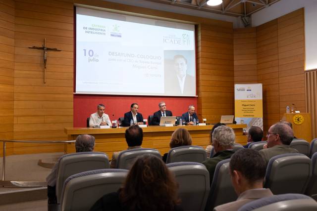 Una conferencia se lleva a cabo en un salón con panelistas sentados frente a una audiencia.