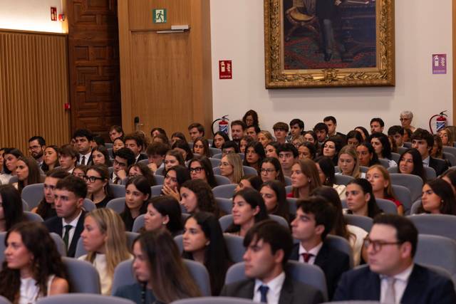 Una multitud de personas sentadas en un auditorio durante un evento formal.