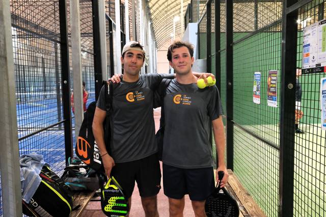 Dos jóvenes sustienen palas de pádel y pelotas en una cancha de pádel.