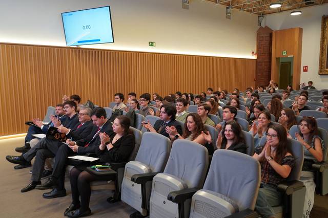 Un grupo de estudiantes aplaude en un auditorio durante un evento.