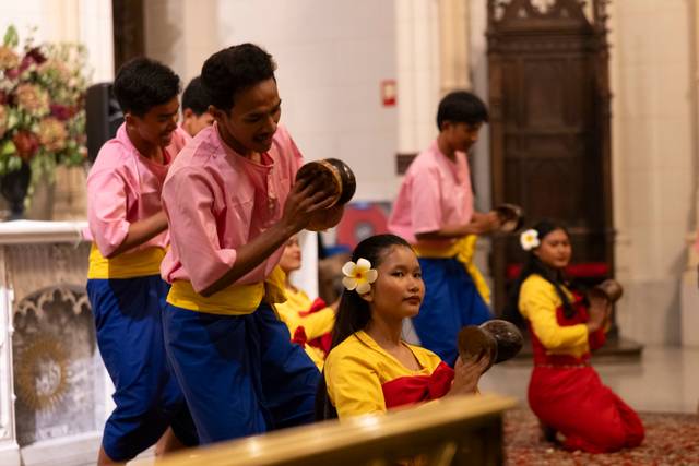 Un grupo de bailarines folclóricos realiza una presentación con vestimenta colorida en un ambiente ceremonial.