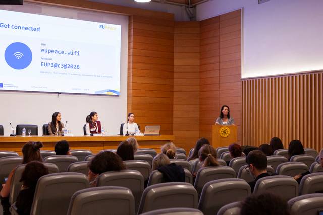 Una ponente habla frente a un auditorio mientras otras tres personas la observan desde el panel.