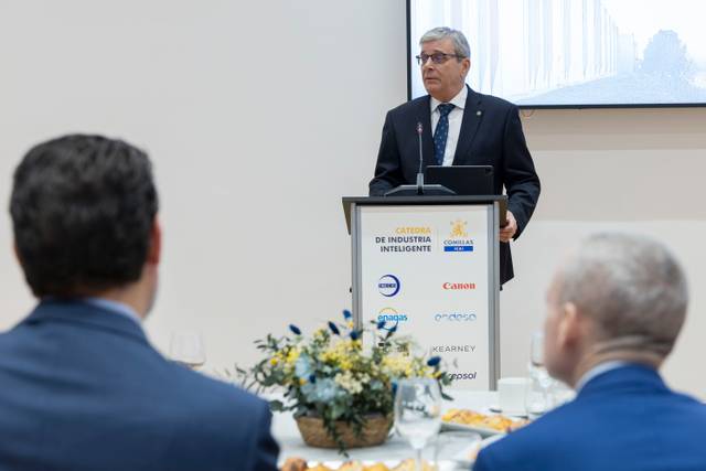 Un conferencista presenta un discurso en un evento de industria inteligente frente a un público atento.
