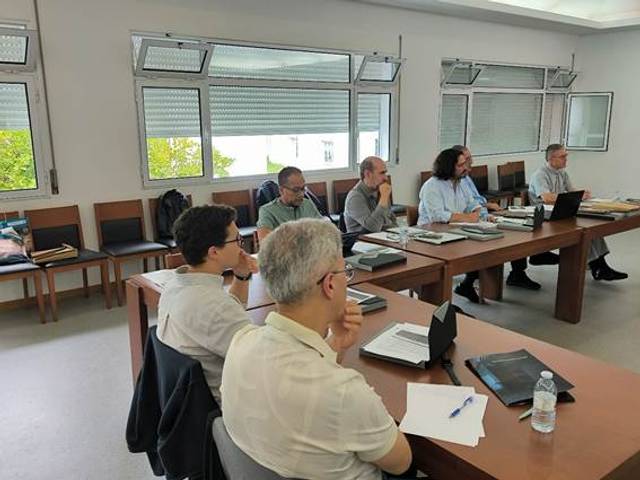 Un grupo de personas sentadas alrededor de una mesa en una sala de reuniones.