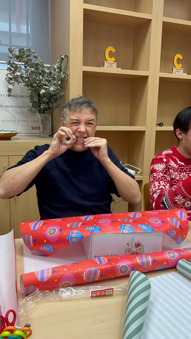 Un hombre en una oficina se está divirtiendo mientras hace gestos con las manos frente a la cámara.