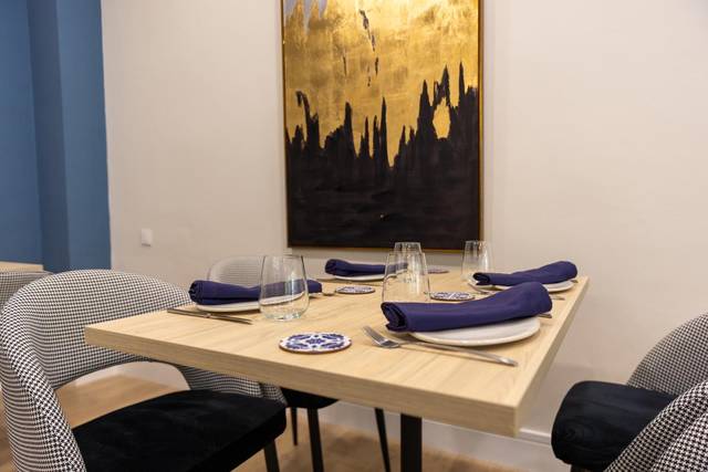 Mesa decorada en un ambiente elegante con arte en la pared.
