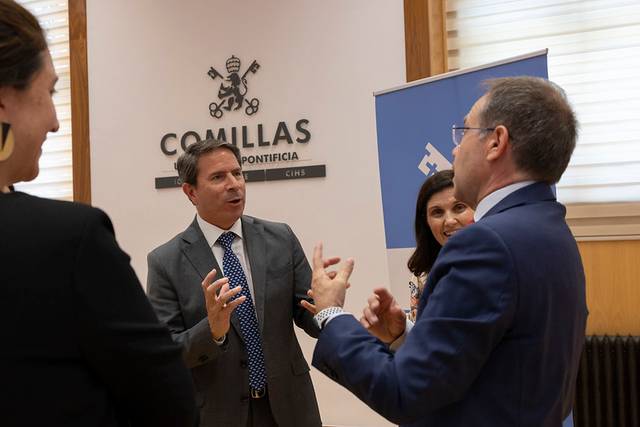 Un grupo de profesionales conversando animadamente en un entorno institucional.